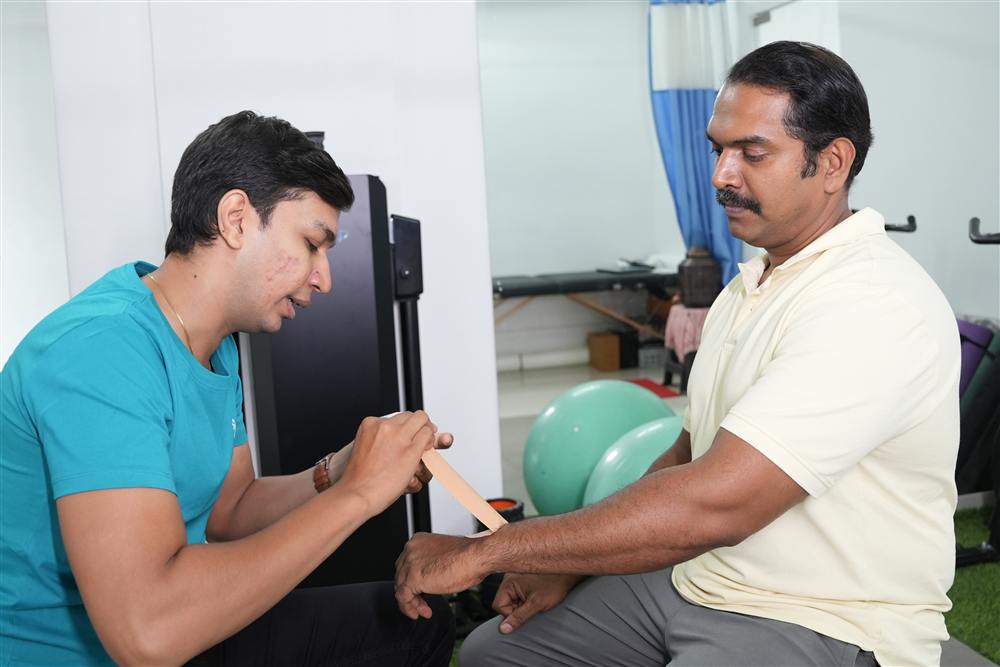 PhysioShine therapist applying functional tape to a patient's arm