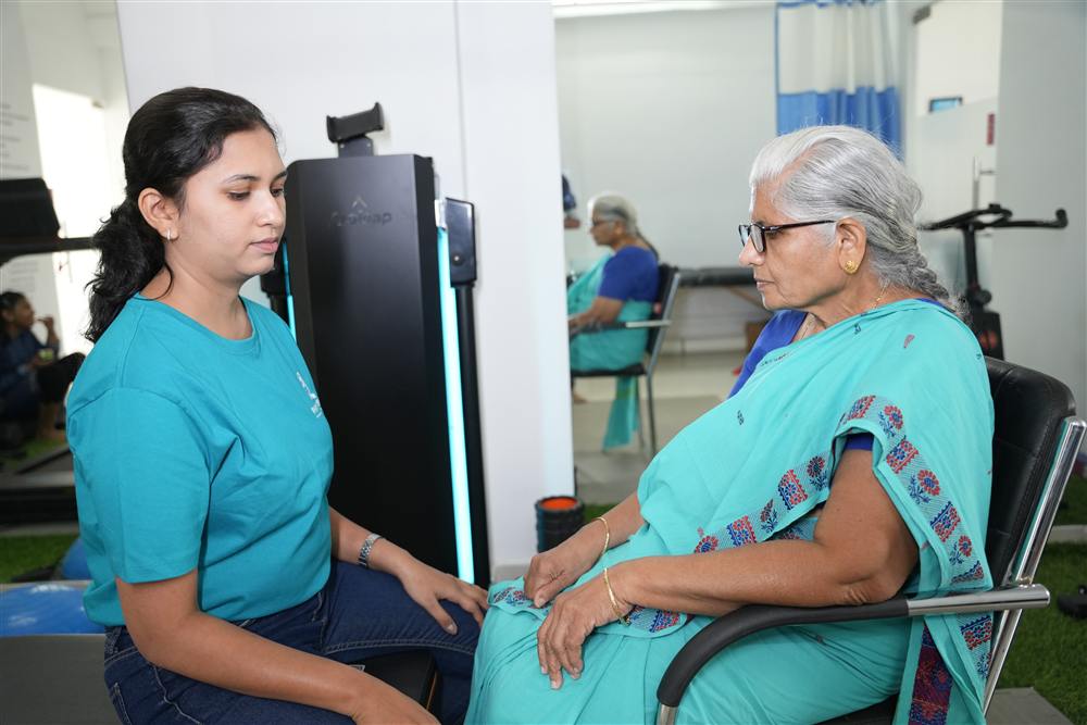 PhysioShine therapist consulting with an elderly patient