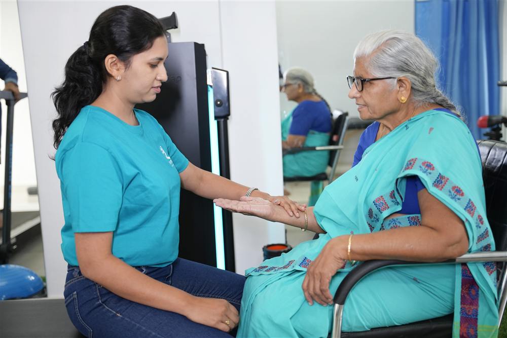 PhysioShine therapist working with an elderly patient on arm mobility
